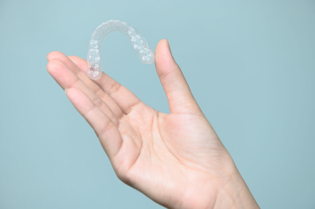 Hand holds Invisalign aligner